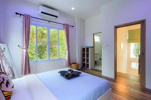 a bedroom with a large white bed and a window at V228 Renovated 3BR Pool Villa Near Top Beaches in Bang Rak Beach