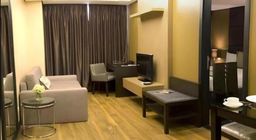 a living room with a couch and a tv at F1 Hotel Manila in Manila