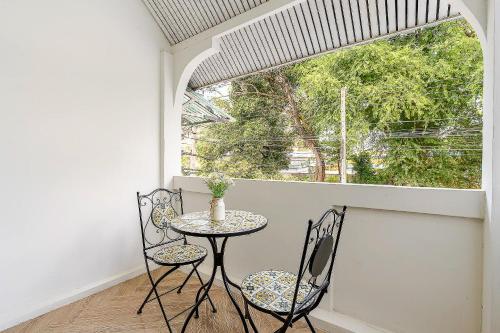 a table and chairs in a room with a window at Kevin's House at Nimman - Premier Suite 2BR 2Bath, Tranquility in Nature in Chiang Mai