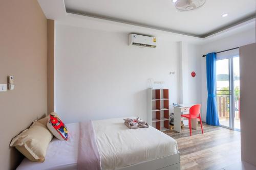 a bedroom with a bed and a desk with a red chair at V228 Renovated 3BR Pool Villa Near Top Beaches in Bang Rak Beach