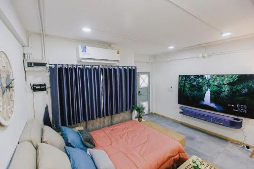 a living room with a couch and a flat screen tv at Kevin's House at Nimman - Premier Suite 2BR 2Bath, Tranquility in Nature in Chiang Mai