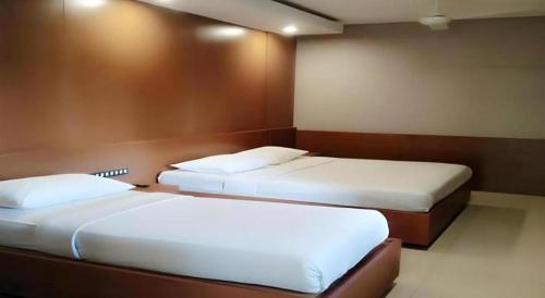 two beds in a hotel room with two bedsvisor at Hotel Bintang Tawangmangu in Tawangmangu