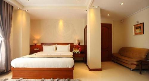 a hotel room with a bed and a couch at Au Lac 2 Hotel in Ho Chi Minh City