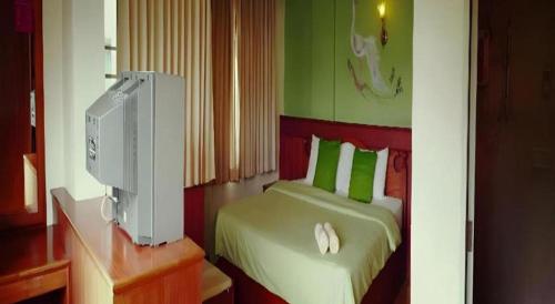 a bedroom with a bed with a computer on a desk at Loei Orchid Hotel in Loei