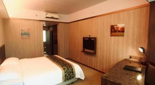 a hotel room with a bed and a television at My Pleasant Hotel in Shenzhen