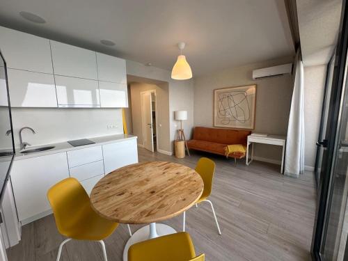 a kitchen and living room with a table and chairs at Beach Tower 33 floor, 3301 in Batumi