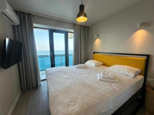 a bedroom with a large bed with a view of the ocean at Beach Tower 33 floor, 3301 in Batumi