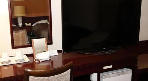 a desk with a large television on top of it at Oita Century Hotel in Oita