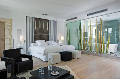 a bedroom with a bed and a living room at Domaine de Verchant & Spa - Relais & Châteaux in Montpellier