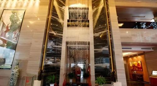 a lobby of a building with a wall of glass at The Prosperous City Hotel Weifang in Weifang