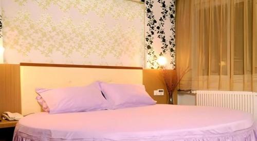 a bedroom with a large bed with purple pillows at Shanshui Trends Hotel-Bantian Dong Branch in Shenzhen