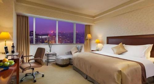 a hotel room with a bed and a desk and a window at Jiaxing Sunshine Hotel in Jiaxing