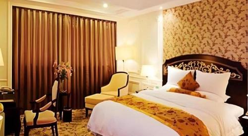 a bedroom with a bed and a desk and a chair at Jinjiang Grandlink Hotel in Quanzhou