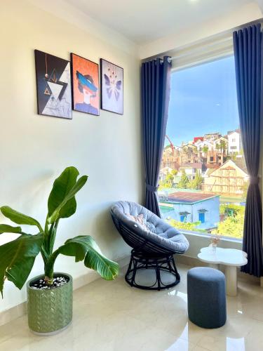 a living room with a blue chair and a window at Cloud River Homestay in Da Lat