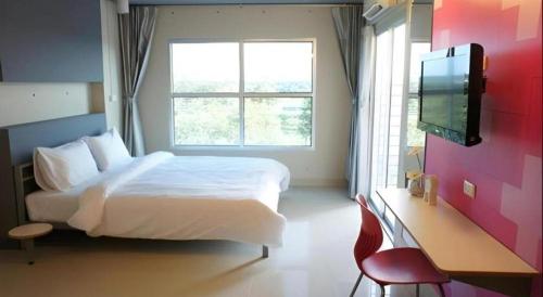 a bedroom with a large bed and a window at A+ Hotel in Ubon Ratchathani