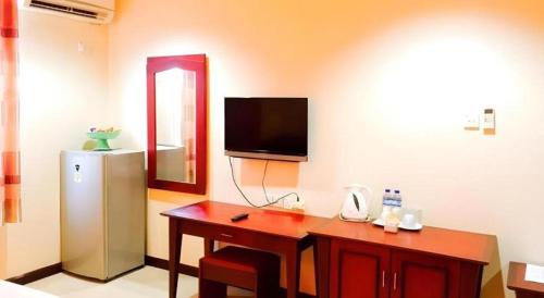 a room with a desk and a television on the wall at Hotel Dynasty in Tarakan