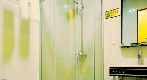 a shower with a glass door in a bathroom at Mount Emei Fulin Hotel in Baoguosi
