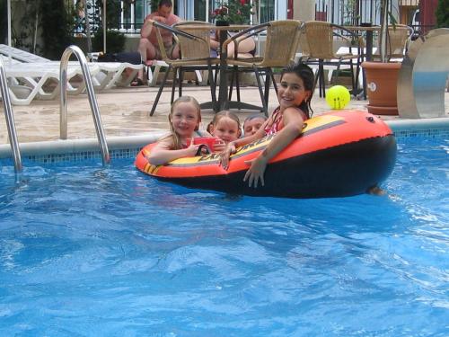 a woman and two children riding on an inner tube in a pool at Hotel L&B- Free parking in Sunny Beach