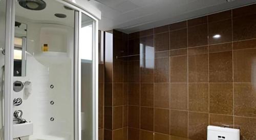 une salle de bain avec douche, toilettes et miroir dans l'établissement Kui Chong Holiday Hotel, à Tongshi