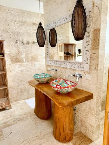 two bowls on a wooden table in a bathroom at Blue Bay Villa in Haad Yao