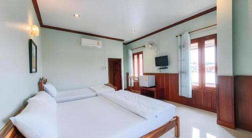 a large bedroom with two beds and a television at Ban Glai Kong in Chiang Khan