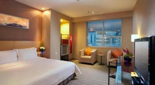 a bedroom with a large bed and a living room at Catic Hotel--Adjacent Buliding in Zhuhai