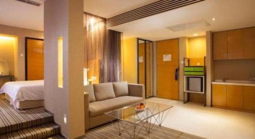 a living room with a couch and a bed at Catic Hotel--Adjacent Buliding in Zhuhai