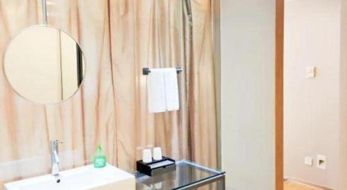 a bathroom with a sink and a mirror at Catic Hotel--Adjacent Buliding in Zhuhai