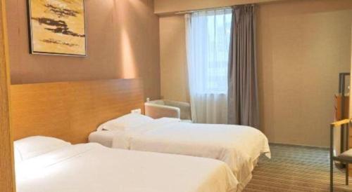 a hotel room with two beds and a window at Catic Hotel--Adjacent Buliding in Zhuhai