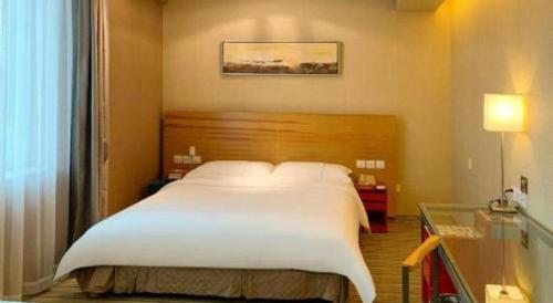 a large white bed in a hotel room at Catic Hotel--Adjacent Buliding in Zhuhai
