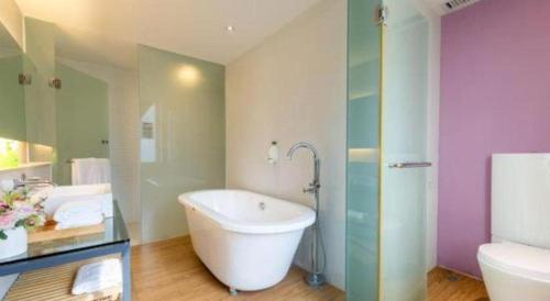 a bathroom with a tub and a toilet and a sink at Catic Hotel--Adjacent Buliding in Zhuhai