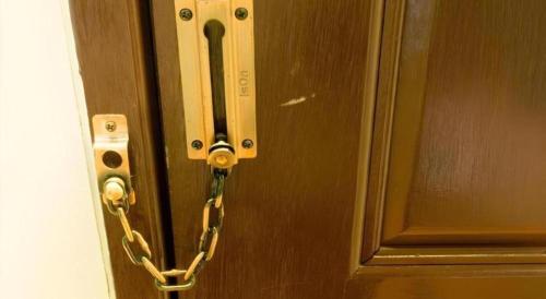 a chain is attached to a wooden door at Baan Kula Mahasarakam in Maha Sarakham