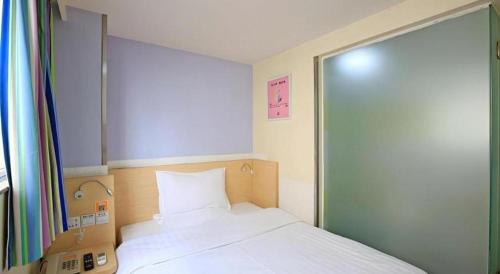a bedroom with a bed and a large glass door at 7 Days Inn Chengdu North Railway Metro Station in Chengdu