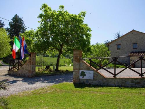 a gate with two flags next to a building at Modern Holiday Home in Pietrafitta Umbria with Garden in Pietrafitta