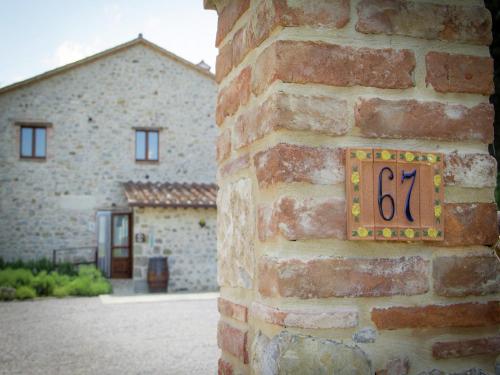 a clock on the side of a brick wall at Modern Holiday Home in Pietrafitta Umbria with Garden in Pietrafitta