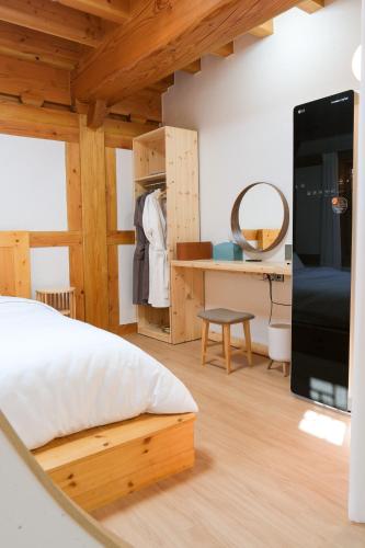 a bedroom with a bed and a desk with a mirror at 경주 황리단길 한옥스테이 다가감 in Gyeongju