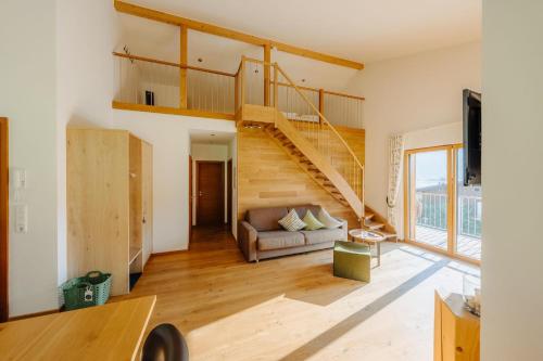 a living room with a staircase and a couch at Landhaus Valfontana in Vandans
