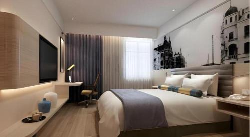 a bedroom with a bed and a desk and a television at Metropolo Hotel Qingdao Wusi Square Xiaomaidao in Qingdao