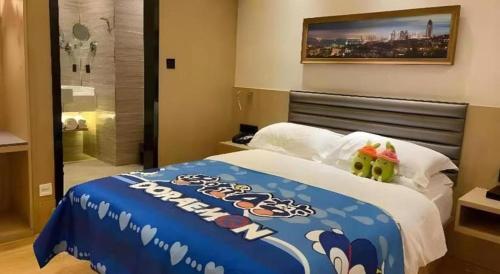 a hotel room with a bed with a blue blanket at Metropolo Hotel Qingdao Wusi Square Xiaomaidao in Qingdao
