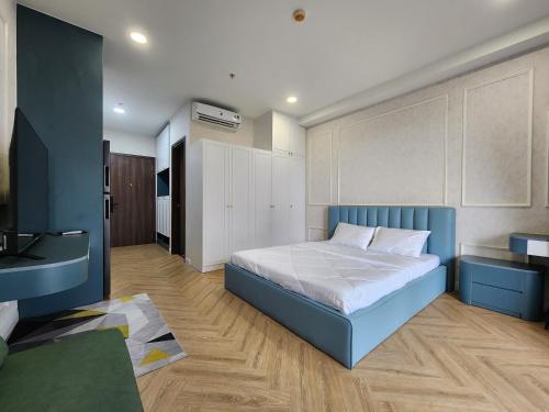 Schlafzimmer mit einem blauen Bett und einem Schreibtisch in der Unterkunft Lang Retreat Apartment - Resort Pool & Elite Gym in Ho-Chi-Minh-Stadt
