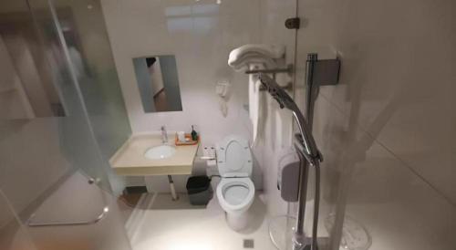 a white bathroom with a toilet and a sink at Shanghai Jiejia hotel in Shanghai