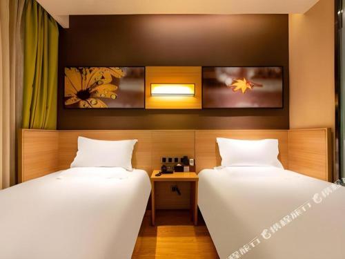 a room with two beds and a desk in it at IU Hotel Kunming Jinma Bijifang Joy City in Kunming