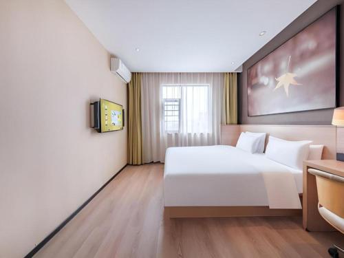 a bedroom with a large white bed and a window at IU Hotel Kunming Jinma Bijifang Joy City in Kunming
