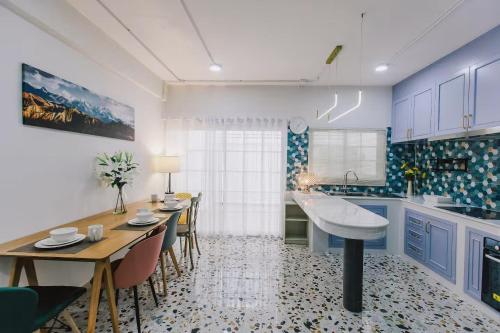 a kitchen with blue cabinets and a table and chairs at Kevin's House at Nimman - Premier Suite 2BR 2Bath, Tranquility in Nature in Chiang Mai