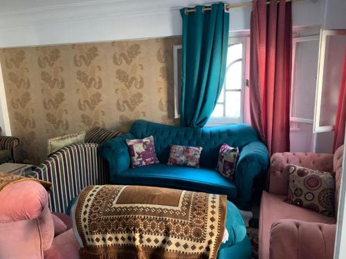 a living room with a blue chair and a table at ELzohor Resort in Alexandria
