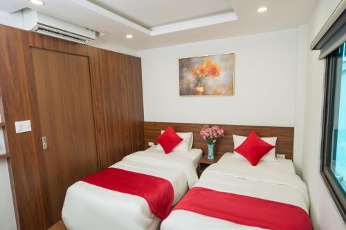 two beds in a room with red pillows at Atypik Vietnam House in Hanoi