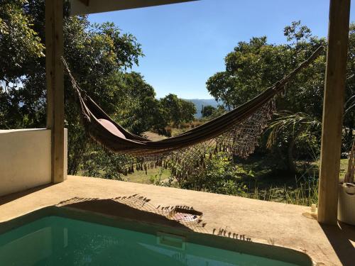 a hammock on the porch of a house with a pool at Ashbourne Country Escape Hazyview in Hazyview