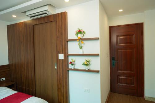 a bedroom with a door and flowers on the wall at Atypik Vietnam House in Hanoi