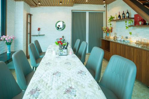 a dining room with a table and blue chairs at Atypik Vietnam House in Hanoi