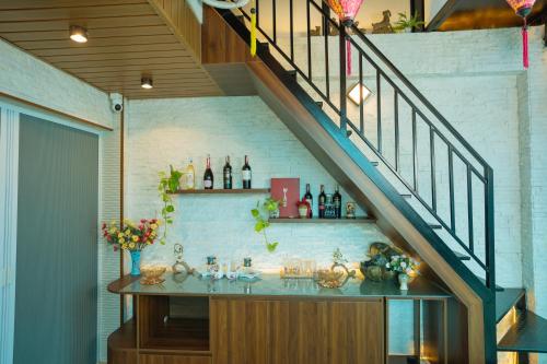 a staircase with a shelf with bottles of wine at Atypik Vietnam House in Hanoi